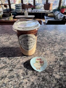A cup of iced coffee and a sticker on a counter